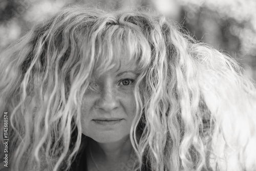 A black-and-white portrait of a woman with Slavic features and straw-colored hair, exuding timeless charm.