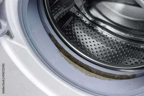 Close-up of dirty rubber gasket with mold and dirt on washing machine. photo