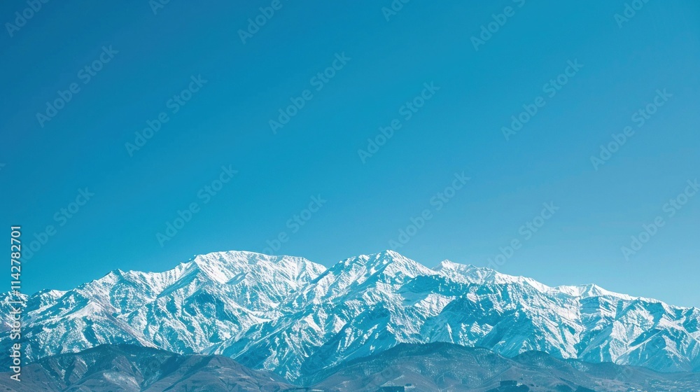 Obraz premium Scenic view of a snowy mountain range under a clear blue sky Nature