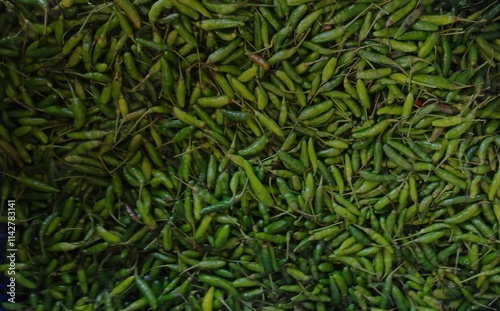 A vibrant mass of fresh green chili peppers, ready for use in a variety of dishes 1