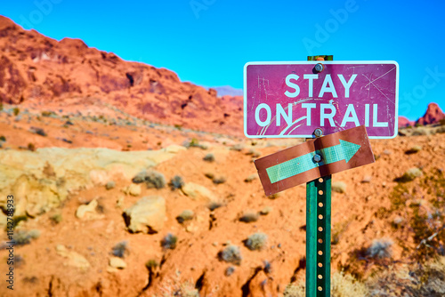 Desert Hiking Path Sign in Moapa Valley with Rugged Rock Background photo