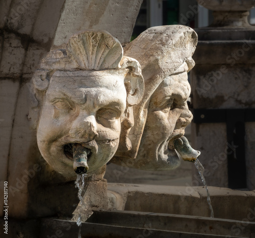 Closeup of the ancient macarons (masks) sculpted in the historical da Ponte fountain, Preseren (Muda) Square, Koper, Slovenia, Slovenia photo