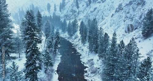 Snowstorm Drone Views of Flowing Payette River and Snowy Forest