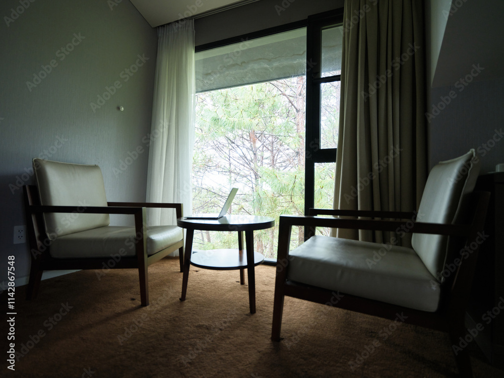 Fototapeta premium Cozy modern living space with two armchairs and a small table, ideal for relaxation and conversations in a serene atmosphere