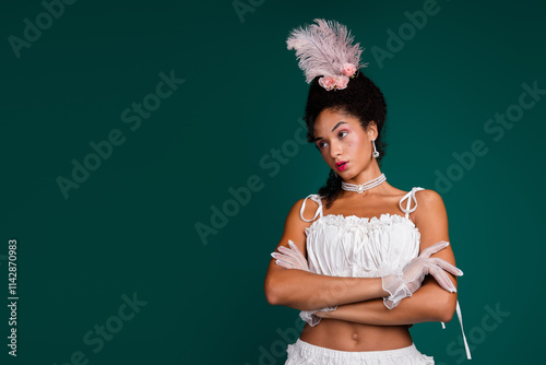 Elegant woman in a historical white costume stands confidently against a rich green background, portraying a blend of vintage elegance