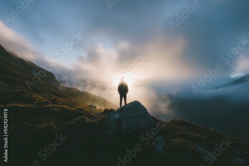 A person stands at the summit of a mountain with breathtaking scenery in the background