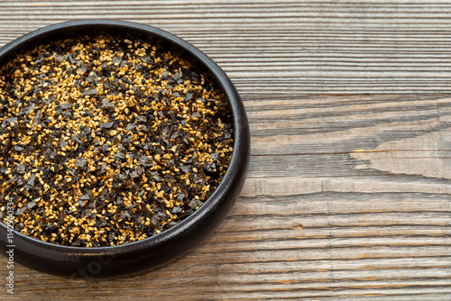 Homemade vegan furikake seasoning with nori seaweed. Japanese cuisine condiment in bowl. Copy space. photo