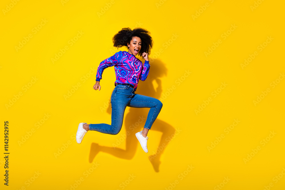 Full body photo of attractive young woman jump running dressed stylish colorful blue clothes isolated on yellow color background Full body photo of attractive young woman jump running dressed stylish colorful blue clothes isolated on yellow color background