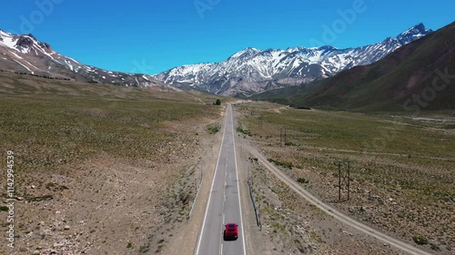 Car riding towards snowy mountains. Aerial view photo