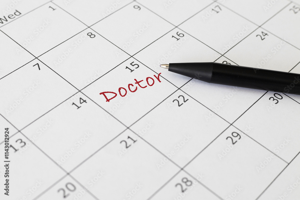 Red Doctos appointment text on calendar. Close up personal medical reminder Red Doctos appointment text on calendar. Close up personal medical reminder