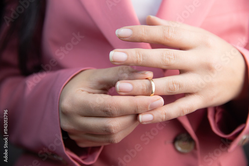 Woman taking off wedding ring indoors photo