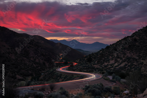 Mountain road at sunset, streaks of light from passing vehicles