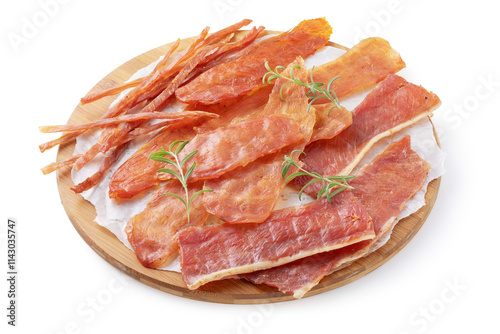 Four types of pork, chicken and turkey meat chips with rosemary sprigs on a round wooden tray isolated on a white background, smoked beer snack