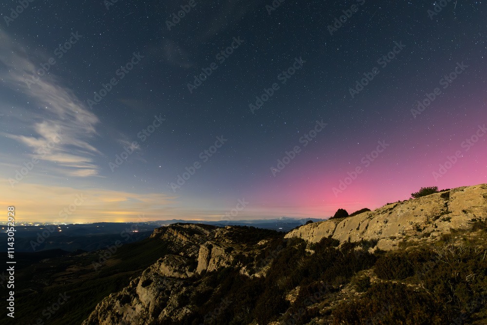 Majestic night landscape showing pink northern lights over Serra Del Montsec, Lleida, Spain. October 2024