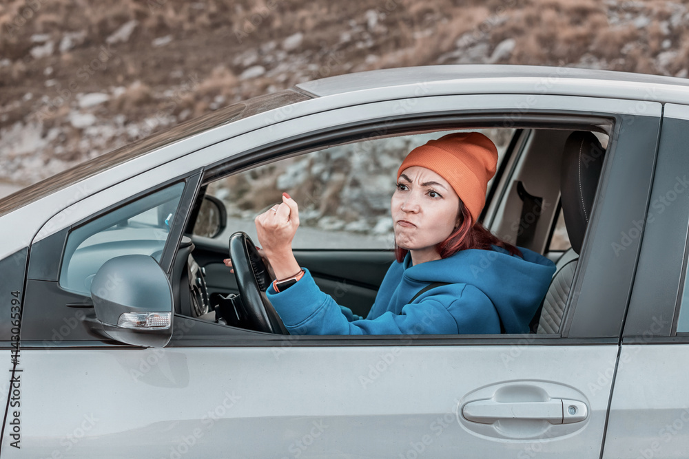 Angry female driver shaking fist at another car while driving