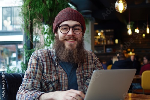 Portrait of a Joyful Hipster Guy Engaged in Freelance Development at a Trendy CafÃ©, Skillfully Coding on His Laptop