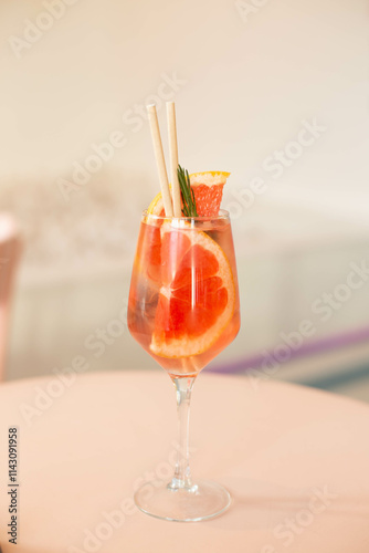 Cold grapefruit cocktail with slices of fresh grapefruit decorated twig rosemary. Sunny day shadows. A refreshing summer mocktail