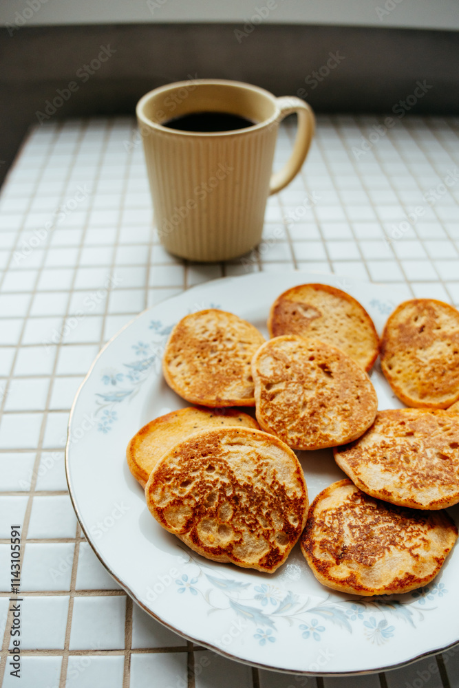coffee and pancakes on plate on kitchen table, breakfast on sunny morning. healthy eating, vegetarian. top view of food. a nutritious lunch, delicious and balanced. coffee and pancakes on plate on kitchen table, breakfast on sunny morning. healthy eating, vegetarian. top view of food. a nutritious lunch, delicious and balanced.