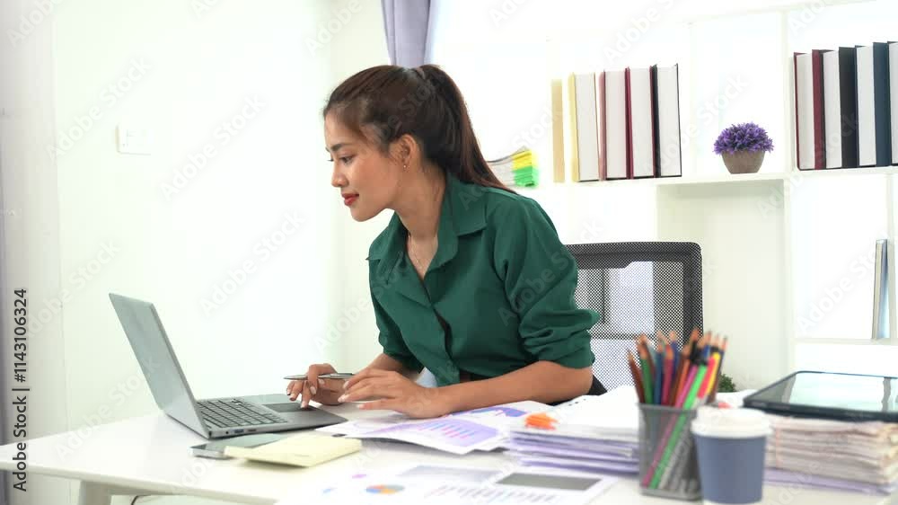 Focused on the Task: A young businesswoman is engrossed in her work, diligently typing on her laptop, surrounded by her organized workspace. She exudes professionalism and determination. Focused on the Task: A young businesswoman is engrossed in her work, diligently typing on her laptop, surrounded by her organized workspace. She exudes professionalism and determination.