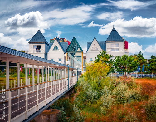 Wonderfful summer view of mettal boat ramp and modern architecture. Pivturesque morning landscape of popular tourist attraction - Heringsdorf Pier with a lots of Shopping mail, Germany, Europe. photo