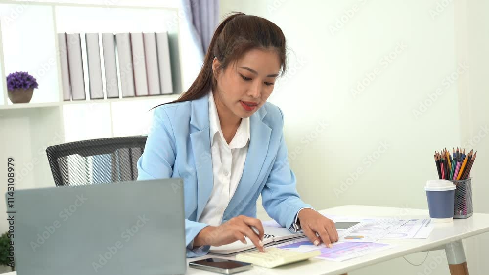 Focused Businesswoman: A professional young woman in a blue blazer, focused on her work, surrounded by her laptop, charts, and a cup of coffee. Focused Businesswoman: A professional young woman in a blue blazer, focused on her work, surrounded by her laptop, charts, and a cup of coffee.