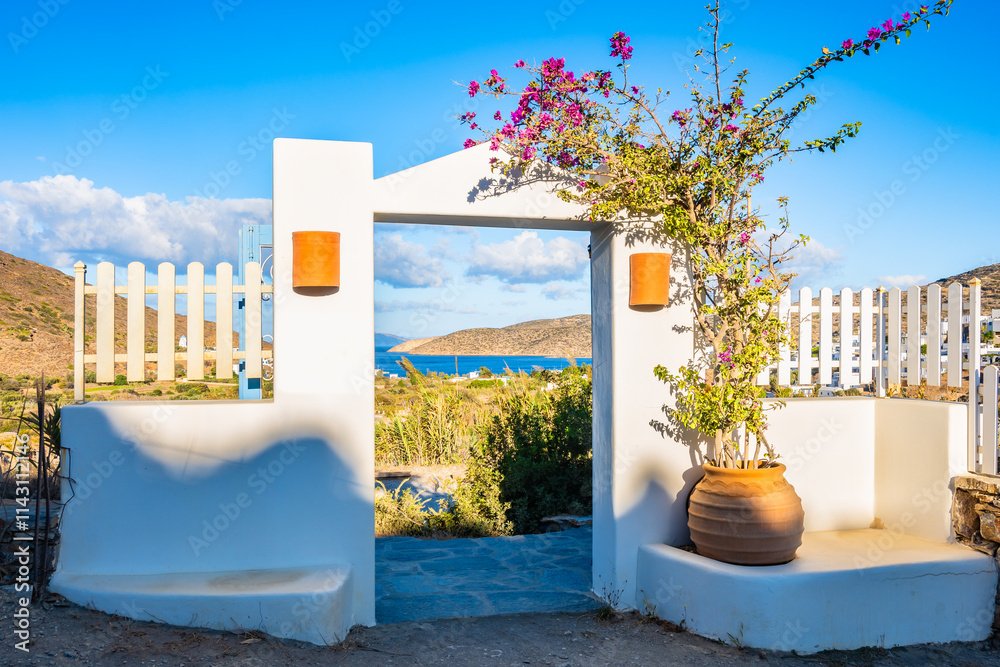 Decorated with flowers entrance gate to typical Greek style holiday apartments in Katapola village, Amorgos island, Cyclades, Greece