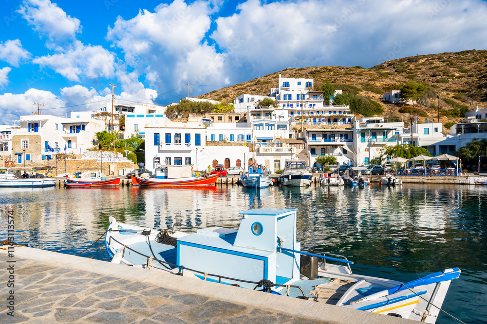 Colorful fishing boats anchoring in Katapola port with white Greek houses in background, Amorgos island, Cyclades, Greece