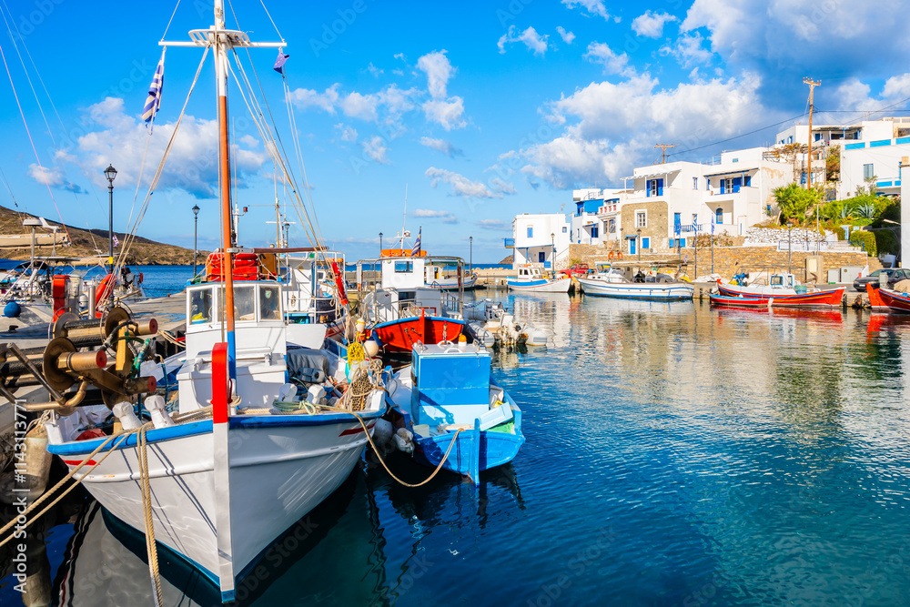 Colorful fishing boats anchoring in Katapola port with white Greek houses in background, Amorgos island, Cyclades, Greece