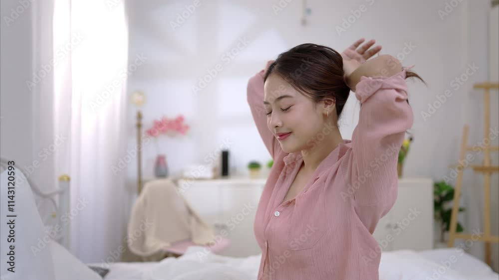 Asian young woman relaxing before bedtime on the bed in the bedroom