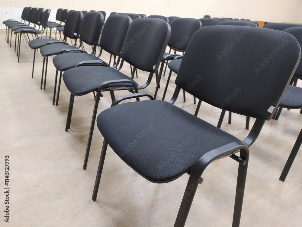 Obraz premium Black soft office chairs with backs stand in empty room before event
