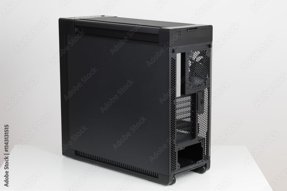 Back side of empty big tower computer case, chassis , effortless maneuvering with two built-in wheels on white background. At the bottom is a place for power supply unit Back side of empty big tower computer case, chassis , effortless maneuvering with two built-in wheels on white background. At the bottom is a place for power supply unit