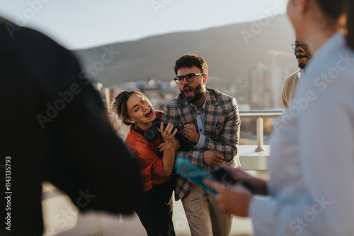 Canvas Print A group of business colleagues celebrate success by dancing on a high-rise balcony at sunset