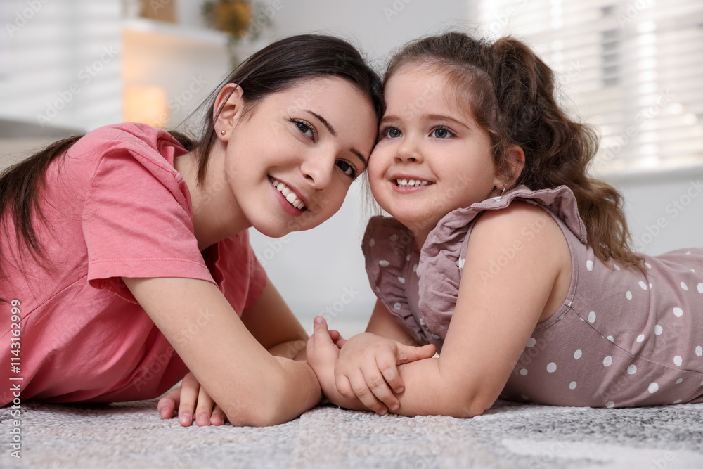 Portrait of cute little girl and her sister indoors Portrait of cute little girl and her sister indoors