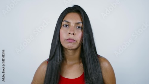 Facial expression of surprise turning to disappointment. Mexican woman in red shirt