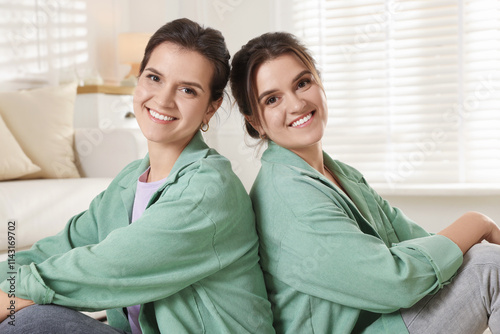 Portrait of beautiful twin sisters at home