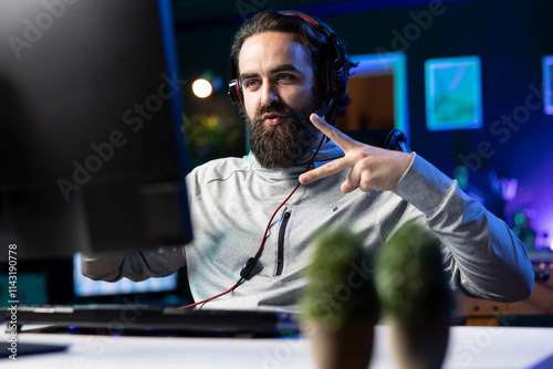 Happy gamer celebrating winning game, killing all enemies and finishing level, throwing peace sign. Delighted player bragging after being victorious in videogame, doing hand gesture