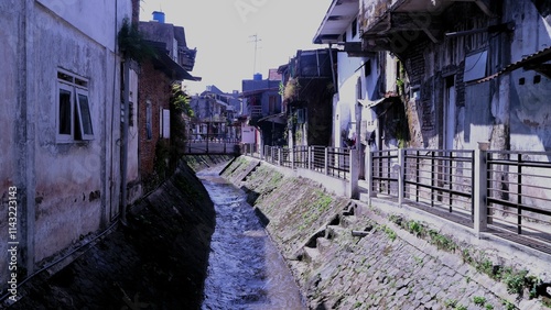 A tranquil river through a densely populated area at Kayutangan heritage in Malang Indonesia. Crumbling houses and river creates a unique travelling destination  for heritage tourism