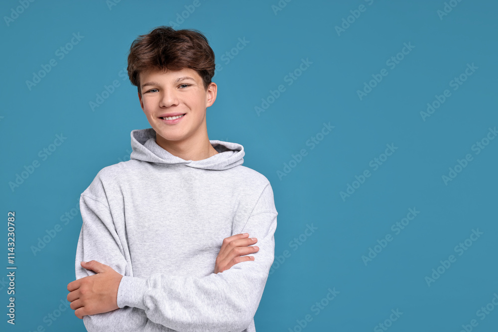Portrait of happy teenage boy on light blue background, space for text Portrait of happy teenage boy on light blue background, space for text