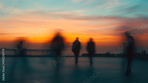 A coastal promenade with blurred walkers silhouetted against a glowing sunset.