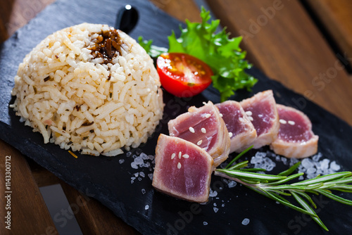 Tasty pan seared sashimi grade tuna (tataki) served with rice, vegetables, greens and soy sauce photo