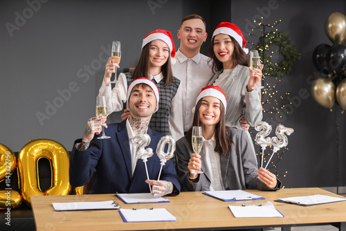 Corporate holiday party, diverse team celebrating new year with champagne and...