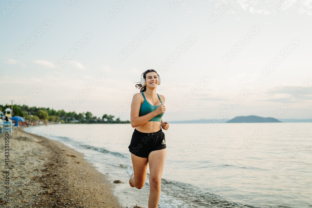 Young woman running or jogging on the beach at sunset Young woman running or jogging on the beach at sunset