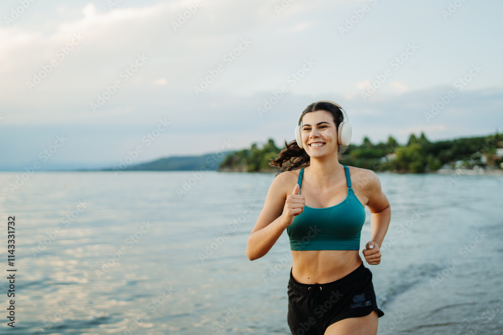 Young woman running or jogging on the beach at sunset Young woman running or jogging on the beach at sunset
