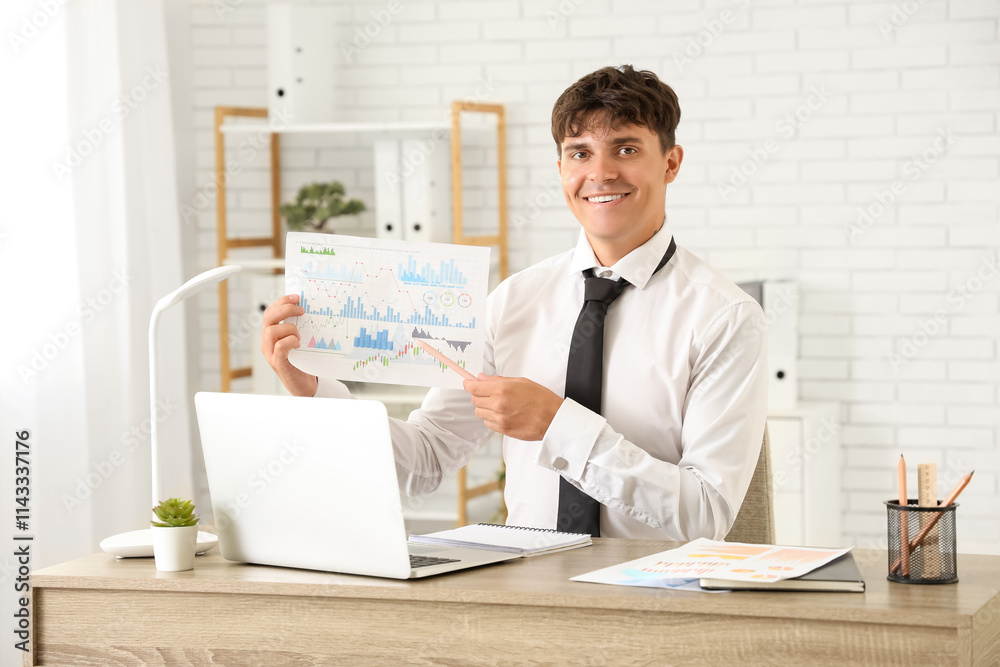 Young businessman working with diagrams at desk in office Young businessman working with diagrams at desk in office