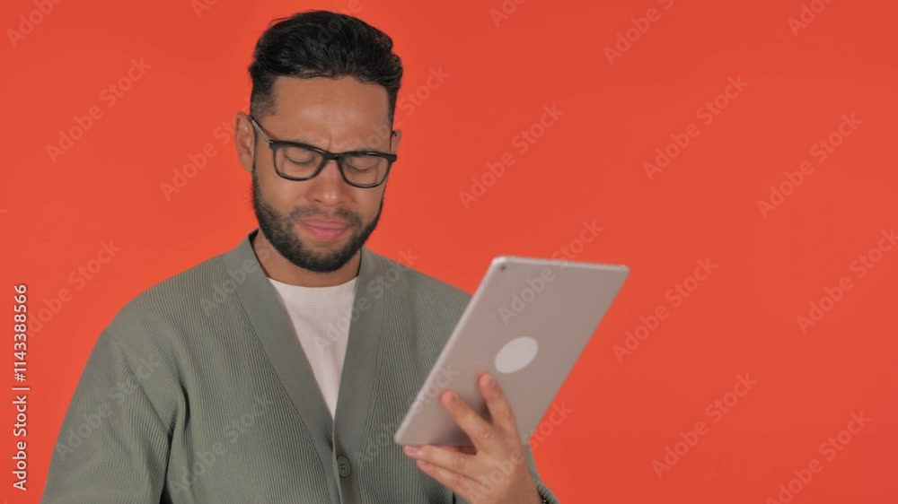 Casual Hispanic Man with Loss on Tablet on Red Background Casual Hispanic Man with Loss on Tablet on Red Background