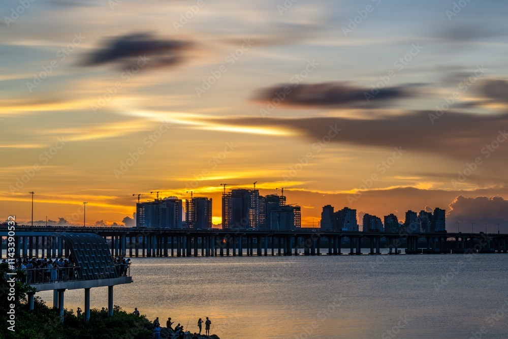 Crowds gather to enjoy a vibrant summer sunset at Qianhai Bay in Nanshan District, Shenzhen Crowds gather to enjoy a vibrant summer sunset at Qianhai Bay in Nanshan District, Shenzhen