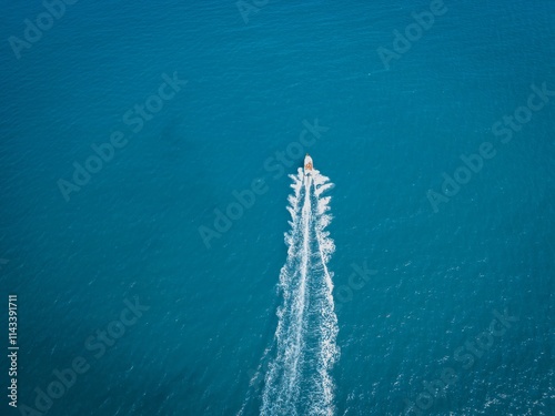 Summer day at Pigeonhole Scenic Area in Beidaihe with a boat navigating turquoise waters photo