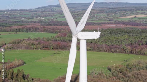 Closeup of Wind Turbine With Meadow And Forest In The Background In Midlands, Laoise, Ireland. - aerial shot photo