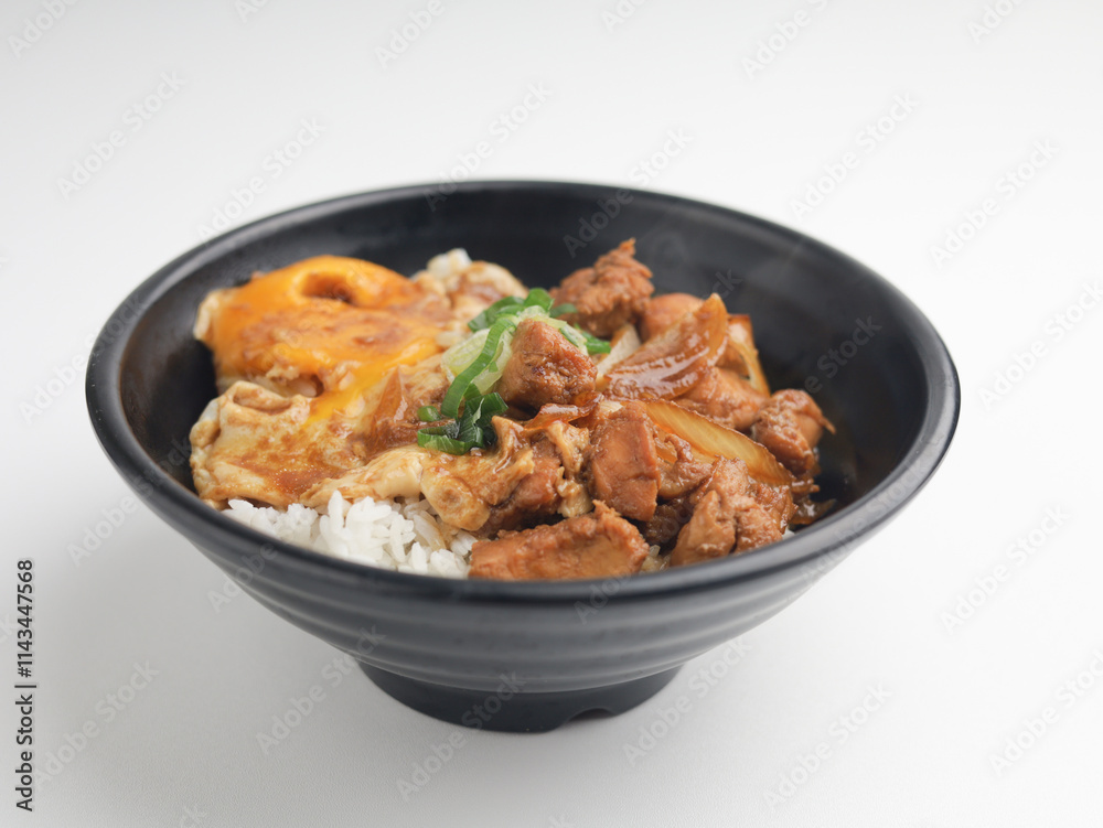 Rice served with chicken teriyaki sauce and sunny side up egg in black bowl Rice served with chicken teriyaki sauce and sunny side up egg in black bowl