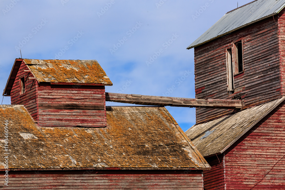 A red barn with a slanted roof and a wooden beam A red barn with a slanted roof and a wooden beam